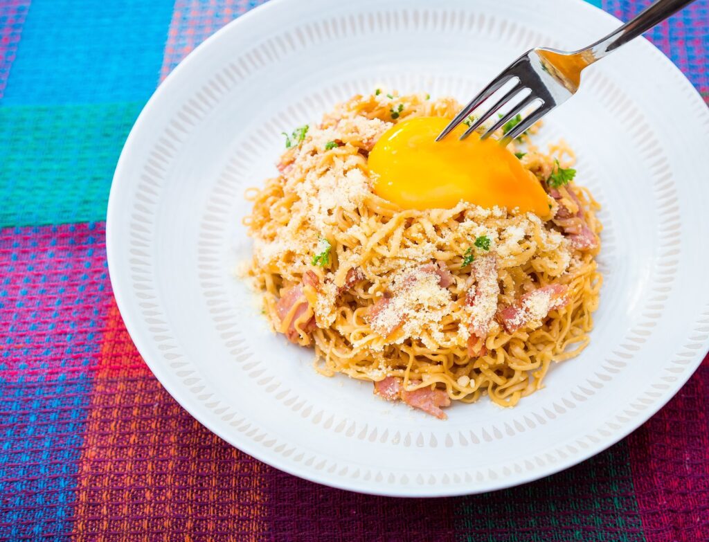 卵や野菜を混ぜたカップ麺の写真